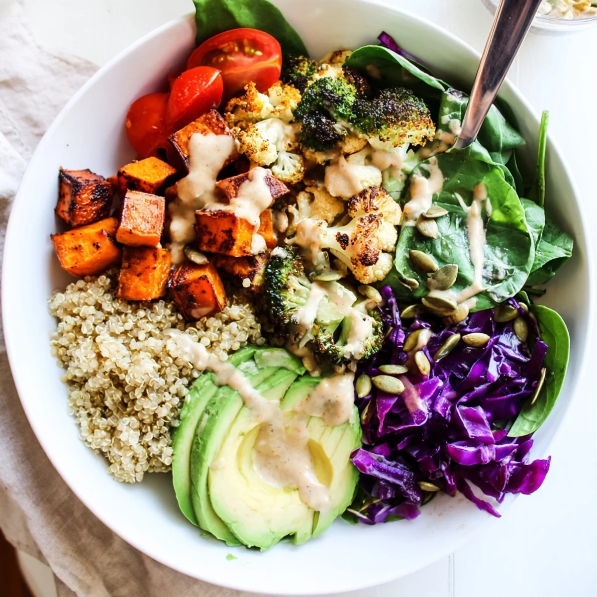 Vibrant vegan Buddha bowl featuring crisp roasted veggies, sliced avocado, and pumpkin seeds