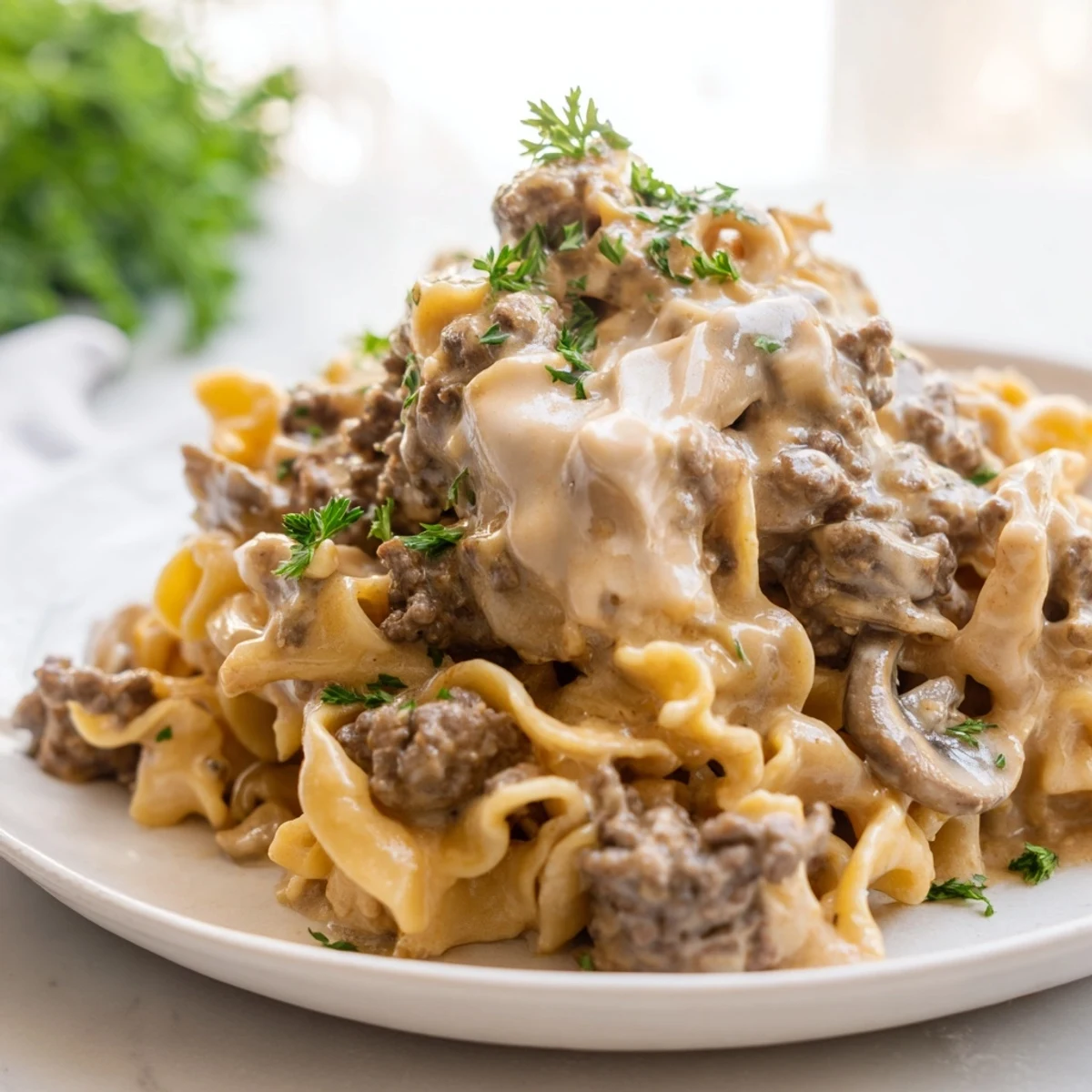 Steaming bowl of hearty hamburger stroganoff topped with fresh chopped parsley