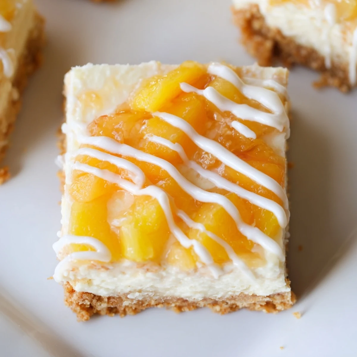 Velvety Peaches and Cream Cheesecake Bars topped with juicy peach chunks and buttery crumbs