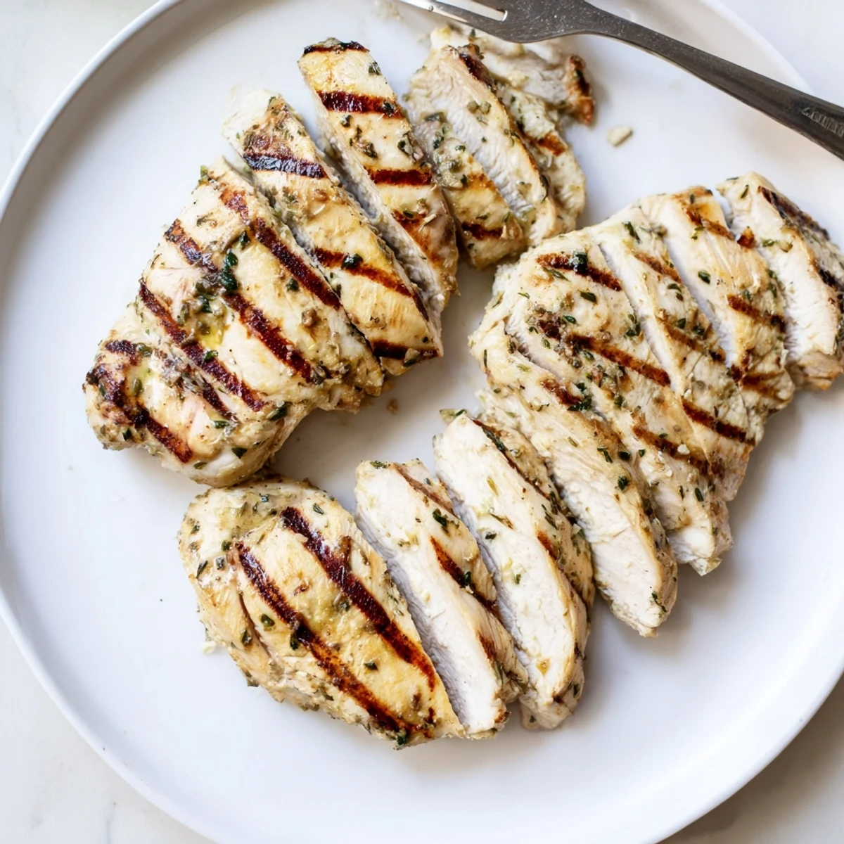 Golden grilled chicken with charred crosshatch marks resting on a wooden cutting board