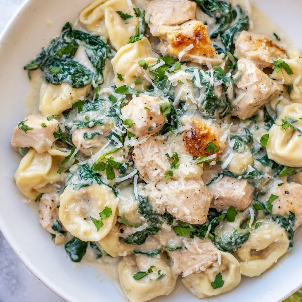 Golden chicken and cheese tortellini nestled in a rich garlic cream sauce with wilted spinach
