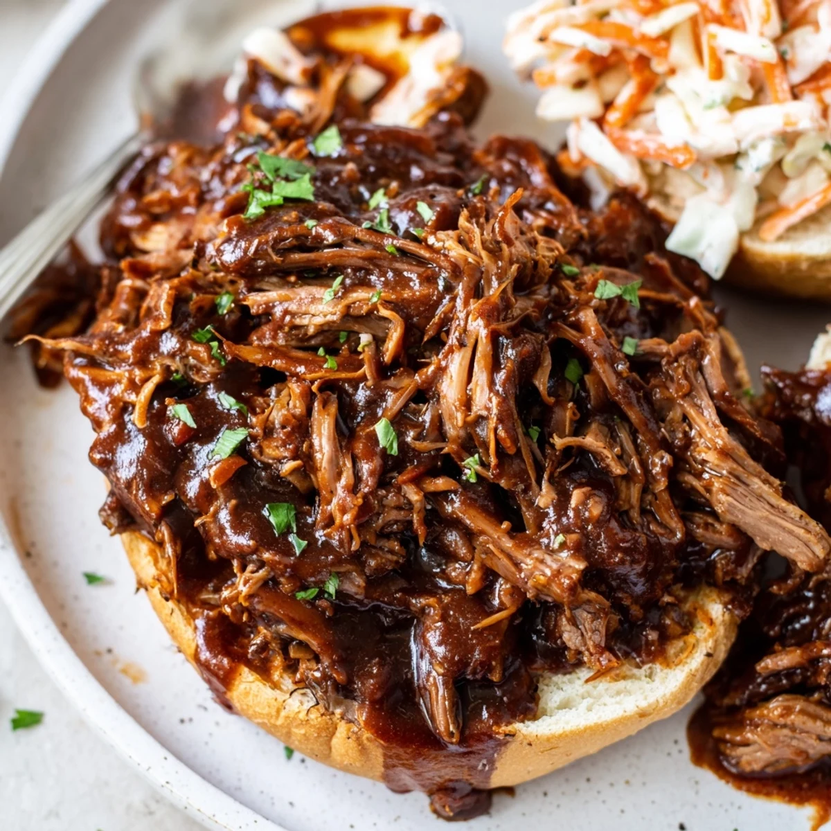 Hearty slow cooker BBQ pulled beef piled high on a toasted bun with creamy coleslaw