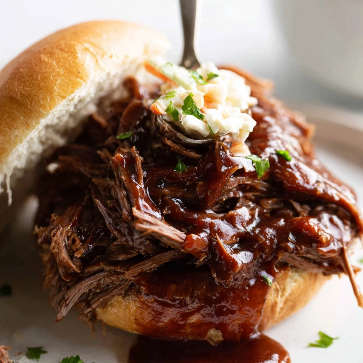 Savory slow cooker BBQ pulled beef shredding apart with a fork, dripping with rich sauce