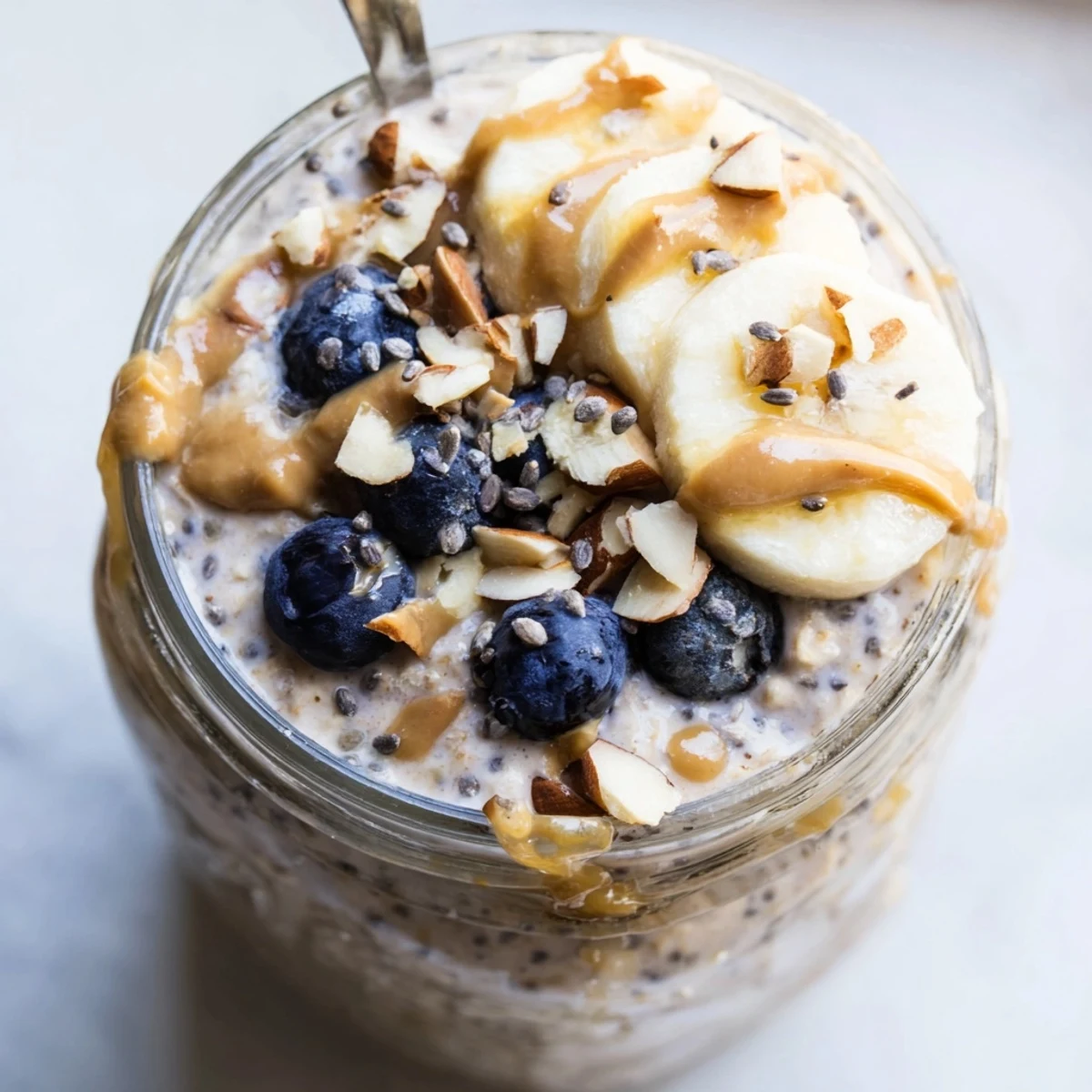 Smooth protein overnight oats served in a jar with chopped nuts