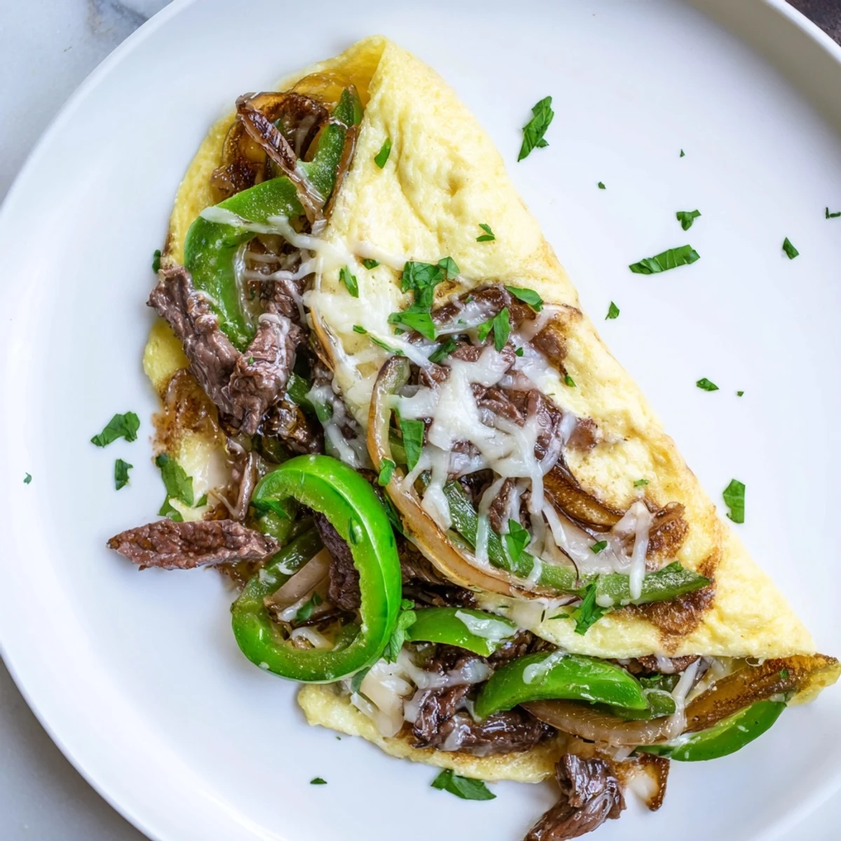 Sliced steak and bell peppers inside a hearty Philly cheesesteak omelette with provolone.
