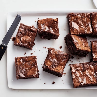 A slice of Fudgy Brown Butter Mochi Brownies reveals a rich, gooey interior studded with melted chocolate chunks and nutty brown butter notes.