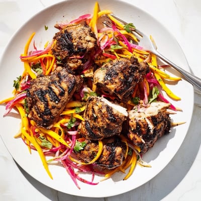 Grilled jerk chicken with juicy mango slaw garnished with fresh cilantro