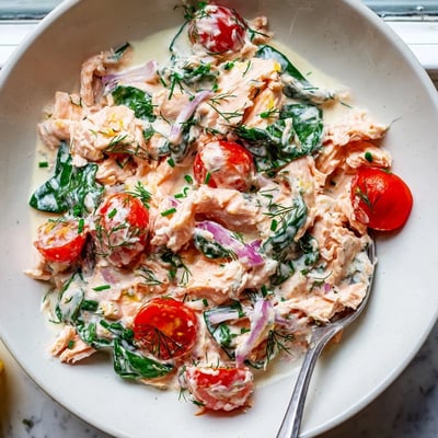 Healthy creamy leftover salmon recipe topped with chives over a bed of quinoa
